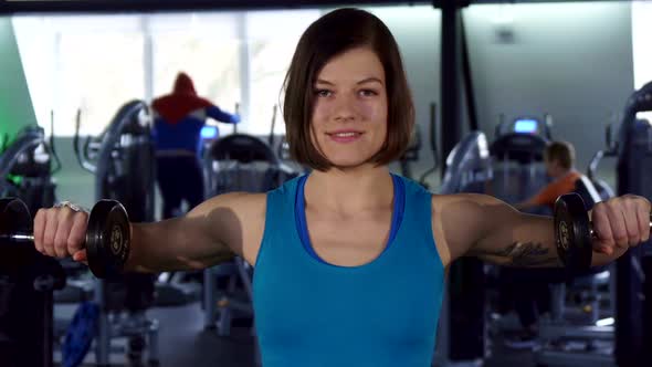 Woman Trains with Dumbbells