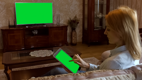 Girl Using Tablet In Front Of The TV 2 With Green Screen alt