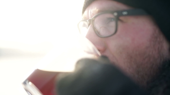 Young Man Drinking Hot Coffee Outdoors In Cold