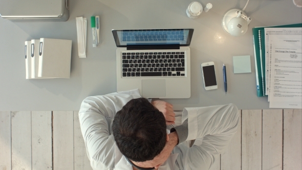 Thinking Doctor With Laptop In Medical Office. Top