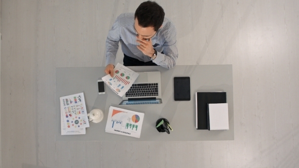 Top View Of Businessman Analyzing Financial Charts alt
