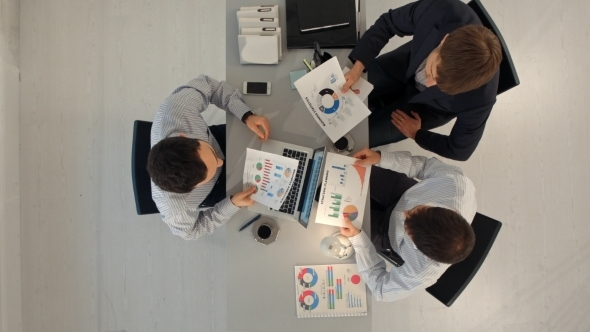 Creative Team Displaying Charts  With Laptop And alt