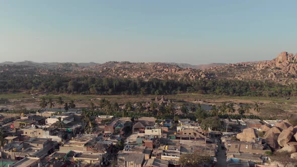 Hampi town's edge with old buildings contrasting with the rocky landscape in Karnataka, India