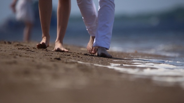Guy and Girl are Walking on the Sand