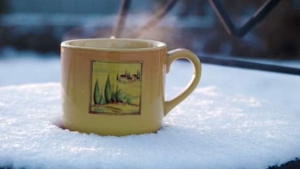 Cup With Hot Tea On a Snow-covered Chair