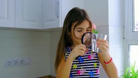 The Child Examines the Water with a Magnifying Glass