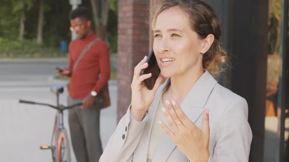 Business Woman Chatting on Smartphone Outside Office