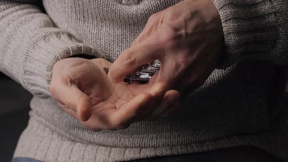 Medical capsules squeezes out of the blister. Men's hands close-up. Lecithin.