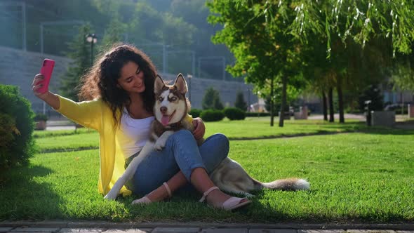 Joyful Girl Making Selfie with a Husky Dog