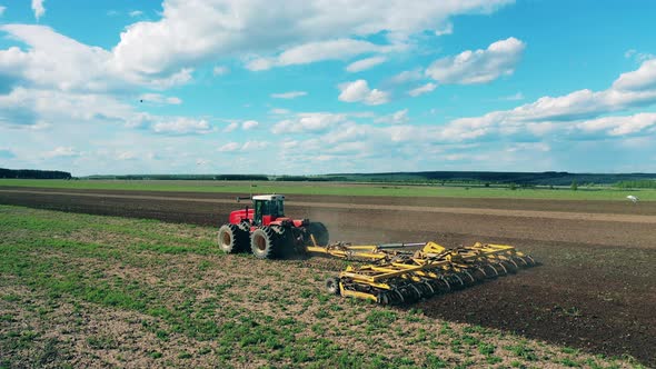 A Tractor Works on a Farm, Plowing Soil.