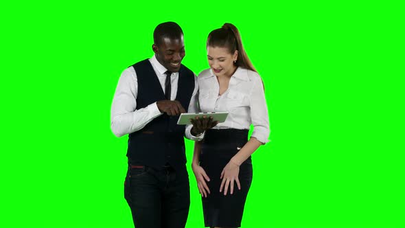 Two Coworkers Look at a Laptop Together. Green Screen