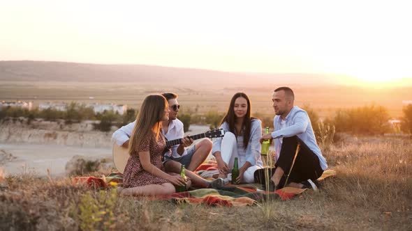 Four Friend Having Fun at Summer Picnic Drinking a Bottle of Beer