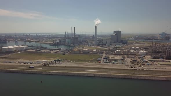 Tower with smoke in industrial harbor of Rotterdam in the Netherlands, Aerial