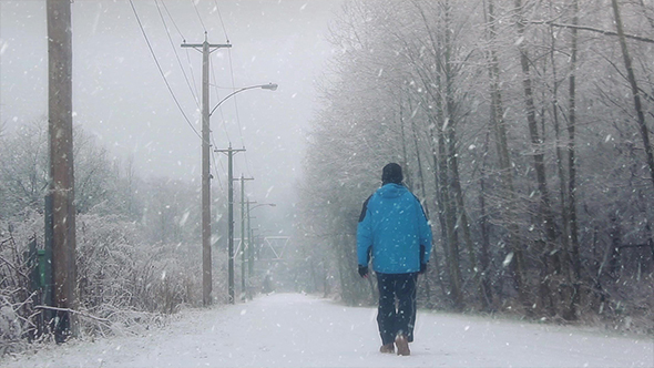 Man Walks On Road In The Snow