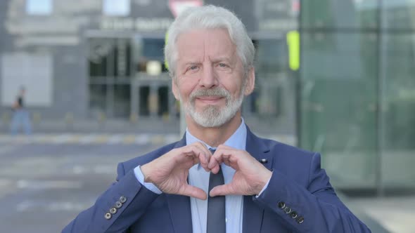 Outdoor Old Businessman Showing Heart Sign