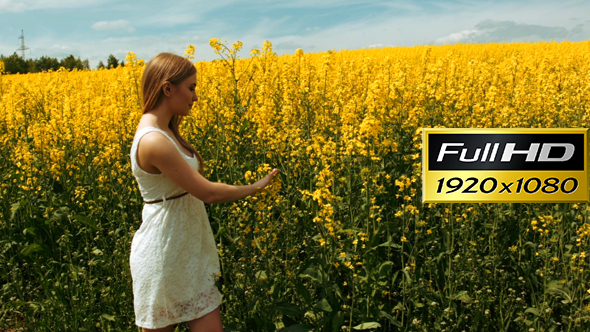 Blond Girl Walking Through The Tall Grass of a Field