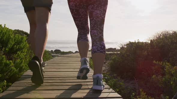 Caucasian couple enjoying free time by sea on sunny day running path