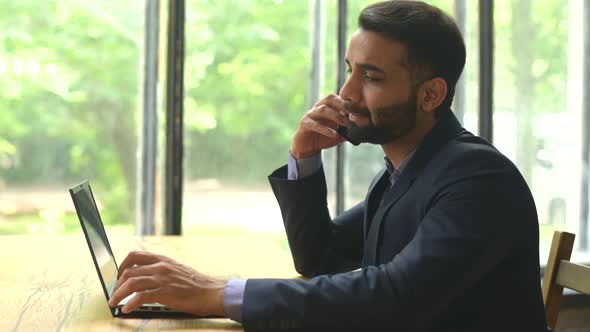 Confident Indian Businessman in Formal Suit Using Laptop for Work