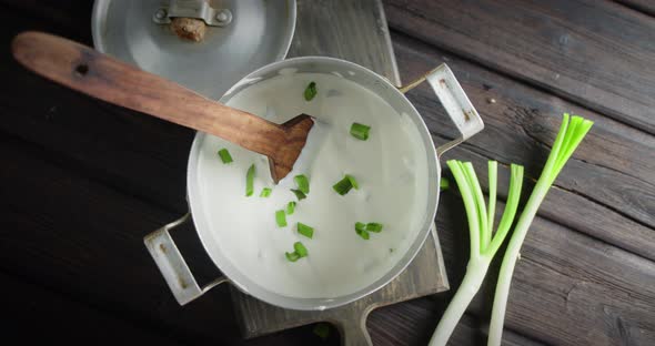 Sour Cream with Green Onion in the Pan Is Slowly Rotated. 