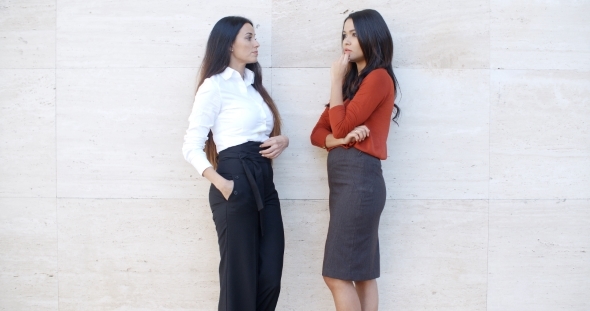 Two Businesswomen Standing Chatting Outdoors