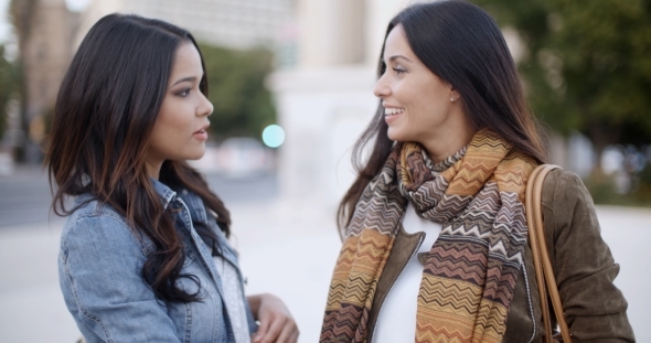 Two Stylish Women Chatting Outdoors In a Town