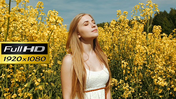 Young Girl Portrait Between Tall Yellow Flowers At Field