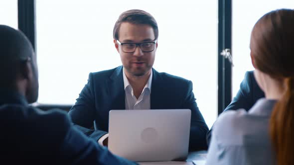 Group of four businessmen applauding each other at the table