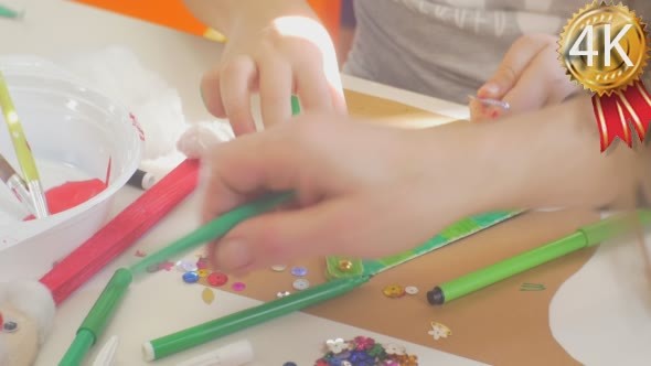 Kids Hands Are Decorating a Triangle With Beads