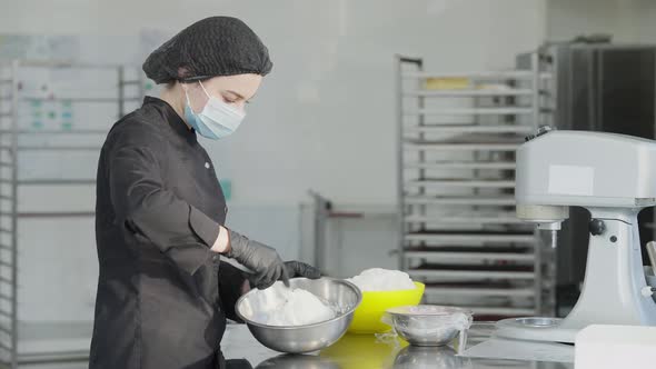 Side View of Confident Beautiful Woman in Coronavirus Face Mask Mixing Confectionery Topping in Slow