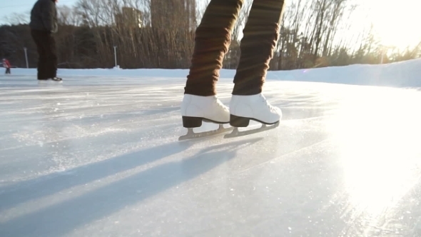 Young Woman Skating On Ice With Figure Skates