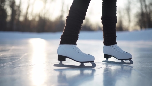 Young Woman Skating On Ice With Figure Skates