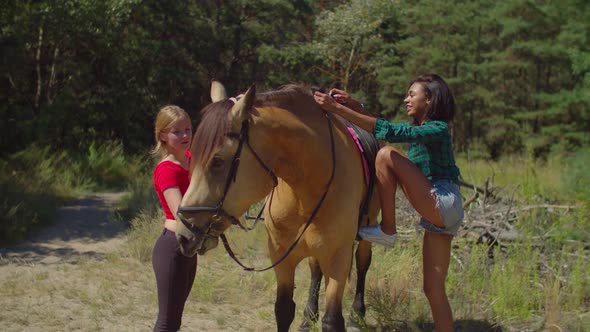 Female Rider Getting in Saddle for Horseback Ride