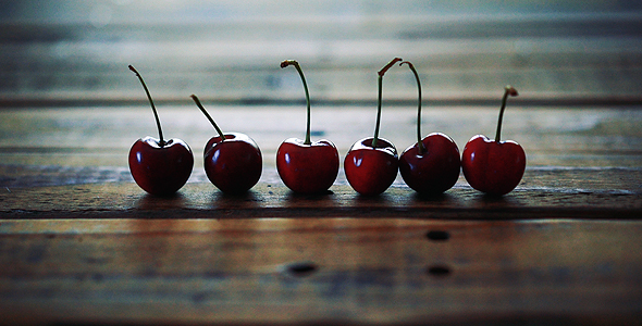Ripe Red Cherries Placed In Line On Wooden Table