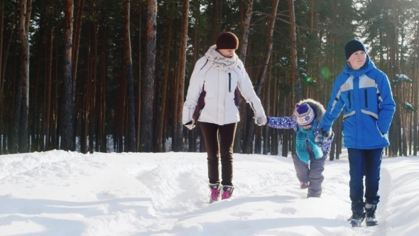 Happy Woman With Two Children Is Walking In The Winter Forest