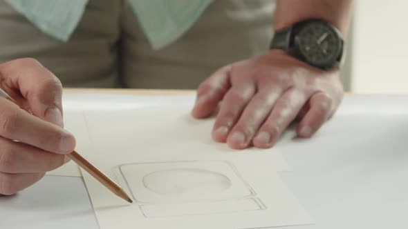 The designer draws a sketch of a perfume bottle with a pencil - the packaging design process. Tilt d