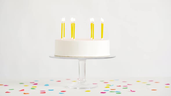 Birthday Cake with Burning Candles on Table