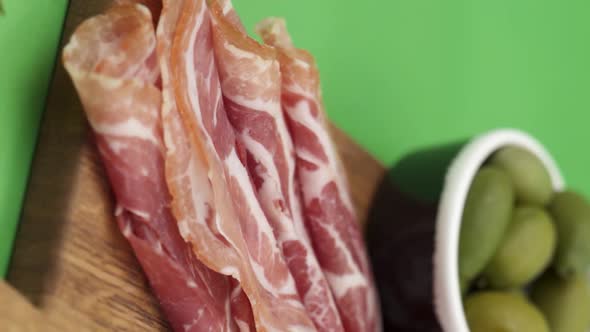 Vertical video, Close-up: cold cuts, salami, prosciutto, jamon, cherry tomatoes, sliced ​​sausage