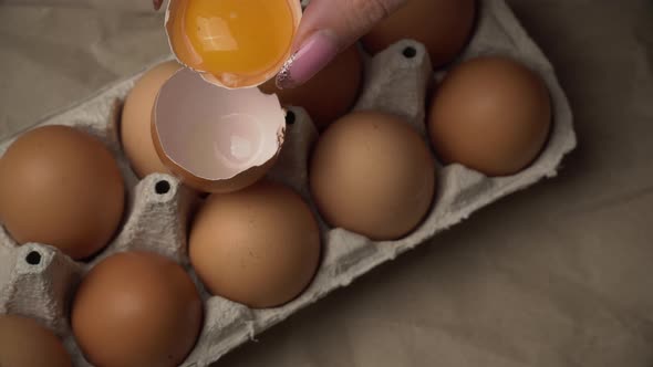 Woman's Hand Pours Chicken Yolk From One Half of the Scarloop to the Other