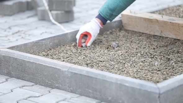 Leveling Gravel a Wooden Board