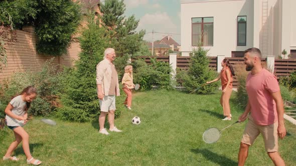 Happy Active Family Playing Sports In Backyard