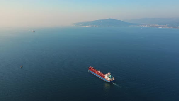 Aerial View of Large Cargo Ship Leaving Sea Harbour at Sunny Day