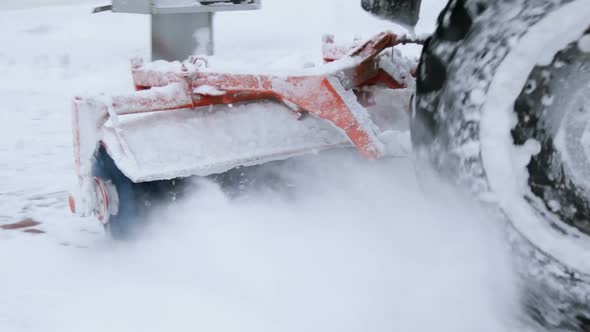 Tractor with Snowplow Equipment Removing Snow From Streets in Snow Blizzard