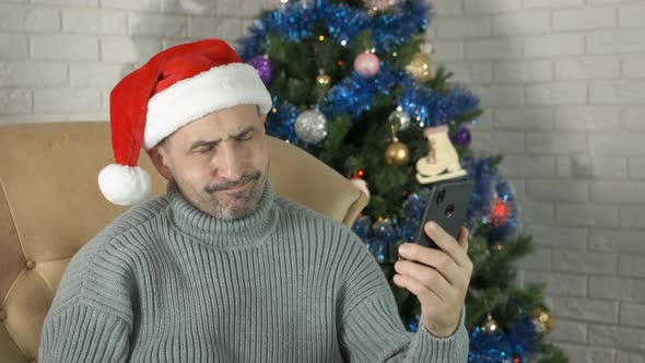 Sad man at Christmas holiday with phone.