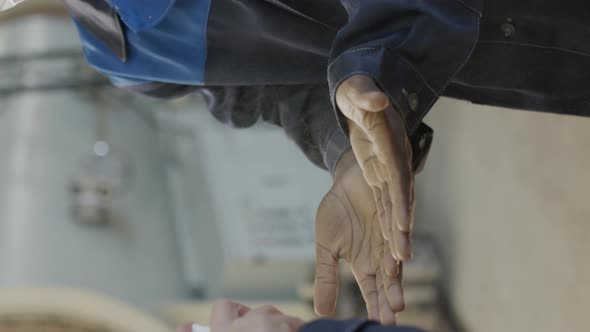  Vertical Shot of Sanitizing Hands of Plant Worker before Shift