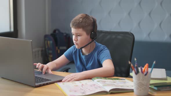 Portrait of boy using laptop computer for distance learning online in living room