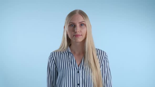 Blonde Young Woman Misunderstanding Something on Blue Background