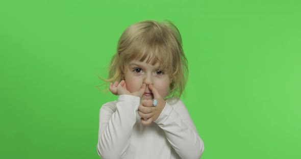 Happy Little Blonde Girl in White T-shirt. Cute Blonde Child. Making Faces