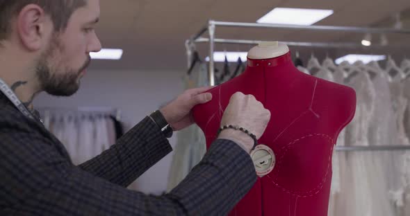 Handsome Designer Draws Dotted Lines on Female Sliding Tailor Dummy in Atelier