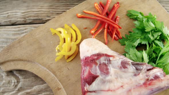 Raw meat, parsley and chopped vegetables on wooden board