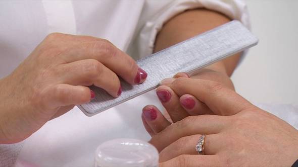 Manicurist Grinding Female Hand Nails With Nail File 